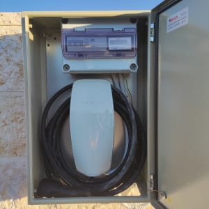 מטען טסלה עם כבלים בתוך ארון חשמל פתוח