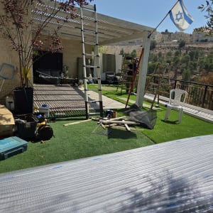 פרגולה מעץ עם סולם ודגל ישראל בחצר