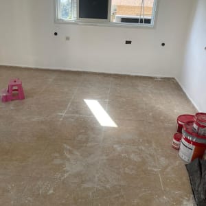 רצפה מלוכלכת עם כתמי צבע ודלי צבע אדום