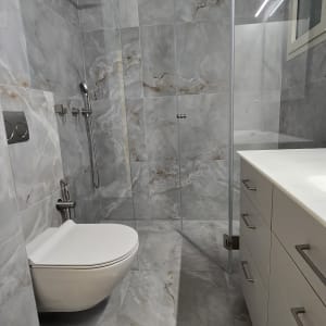 חדר אמבטיה עם מקלחון ושירותים מודרניים