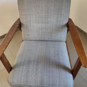 כיסא מרופד עם מסגרת עץ על רצפת אריחים
