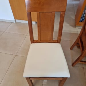 כיסא עץ עם ריפוד לבן על המושב