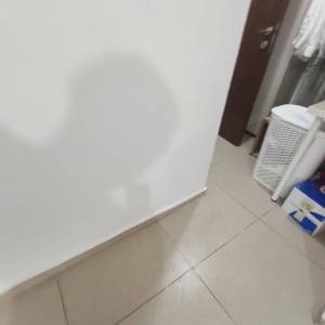 קיר לבן עם צללים על הרצפה