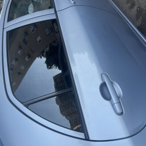 חלון רכב כהה עם השתקפות בניינים