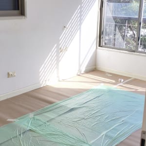 חדר עם קירות צבועים ויריעות מגן על הרצפה