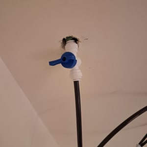 ברז פלסטיק כחול מחובר לצינור שחור בתקרה