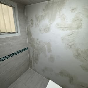 קיר עם טיח חלקי בחדר אמבטיה