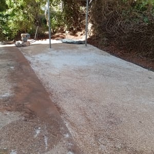 שטח חצץ עם מכונת דחיסה לגינון