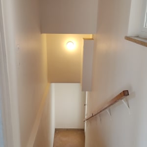 מדרגות עם קירות צבועים בלבן ותאורה עליונה