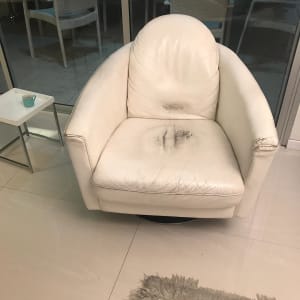 כורסה לבנה עם ריפוד בלוי וכתמים כהים