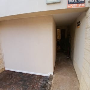 קיר מסויד ומעבר חיצוני עם שלט טלפון