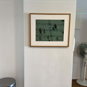 תמונה ממוסגרת על קיר לבן עם מאוורר ופח אשפה