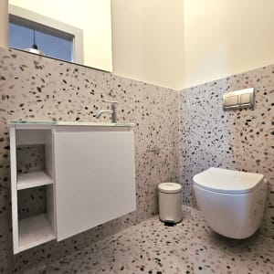 חדר אמבטיה עם כיור, אסלה וקירות מחופים באריחים