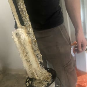 אדם מחזיק גוף חימום עם אבנית מסולארי