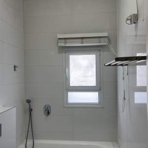 חדר אמבטיה עם אריחים לבנים, אמבטיה וברז חדש