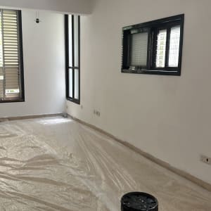 חדר עם יריעת ניילון ודלי צבע על הרצפה