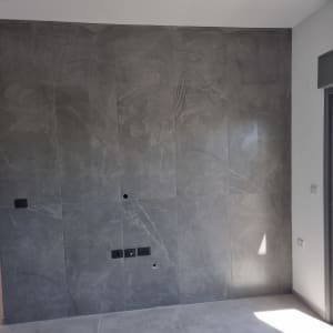 קיר עם אריחים אפורים ושקעים חשמליים