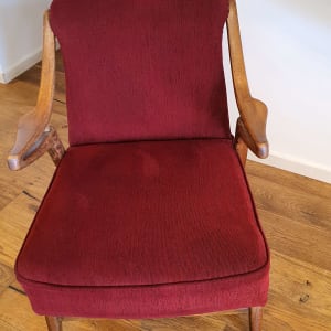 כיסא אדום עם מסגרת עץ על רצפת עץ