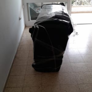 רהיט עטוף בניילון מוכן להובלה במסדרון צר