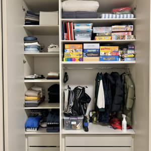 ארון בגדים מאורגן עם בגדים, משחקים ומוצרי ניקוי