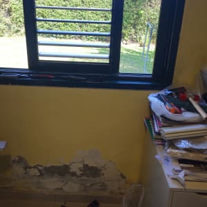 חלון עם תריסים וכלים לתיקון על שולחן