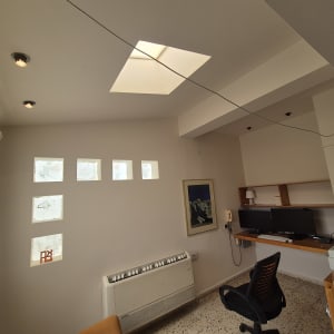 חדר עבודה עם מחשבים, כיסא ותאורה טבעית