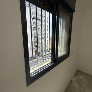 חלון עם סורגים ונוף לבניין מגורים