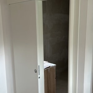 דלת הזזה לבנה בחדר עם קיר לבן