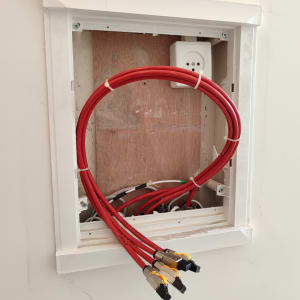 כבלים אדומים עם מחברים בתיבת תקשורת בקיר