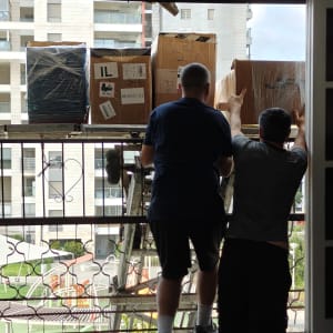 שני אנשים מעבירים קופסאות דרך חלון