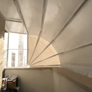 סוכך לבן עם קורות תומכות על קיר חיצוני