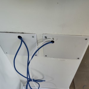 כבלים כחולים ולבנים יוצאים מלוח קיר