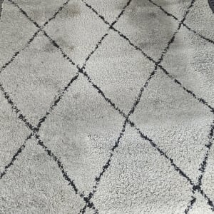 שטיח עם כתמים כהים על רקע בהיר