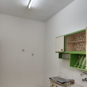 קיר צבוע בלבן עם ארון ירוק במטבח