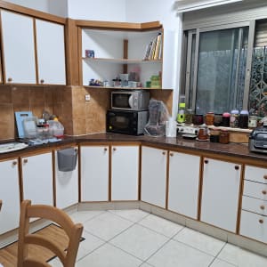 מטבח מאורגן עם ארונות, מכשירי חשמל וצנצנות על השיש