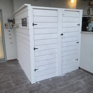 מחסן עץ לבן עם דלתות ובריחים שחורים