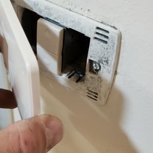 התקנת מתג חשמל בקיר על ידי חשמלאי