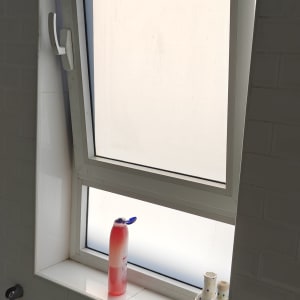 חלון עם תריסים פתוחים למחצה בחדר אמבטיה