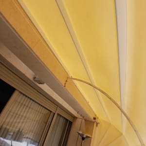 סוכך צהוב מתוח מעל חלון זכוכית