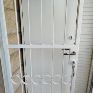 דלת מתכת צבועה בלבן עם מנעול ומפתח