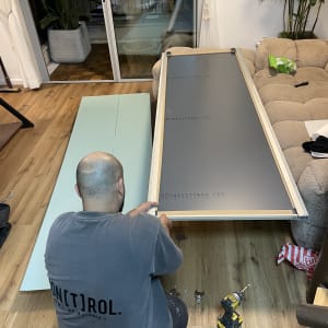 אדם עובד על מסגרת זכוכית עם כלים