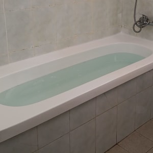 אמבטיה מלאה במים עם אריחי קרמיקה מסביב