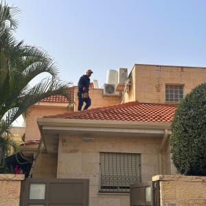 אדם על גג רעפים עם ציוד עבודה