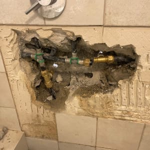 צנרת חשופה בקיר עם חיבורים ותיקונים