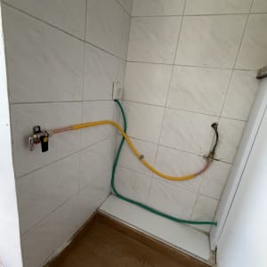 חיבורי גז על קיר עם אריחים לבנים