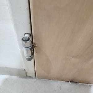 ציר דלת מתכת על משטח עץ