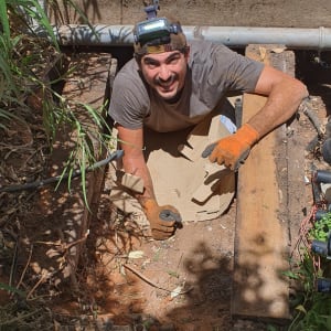 חשמלאי עם פנס ראש וכפפות כתומות בעבודת שטח