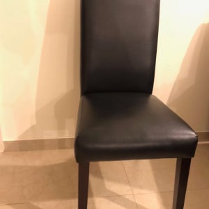 כיסא מרופד בעור שחור עם רגלי עץ