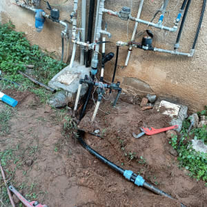 צנרת מים עם ברזים וכלי עבודה על הקרקע