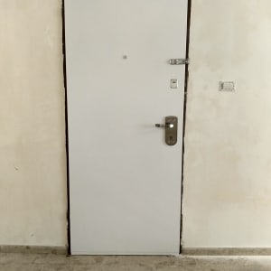 דלת לבנה עם ידית ומנעול כסופים